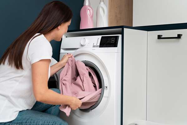 femme prenant des vetements de la machine a laver